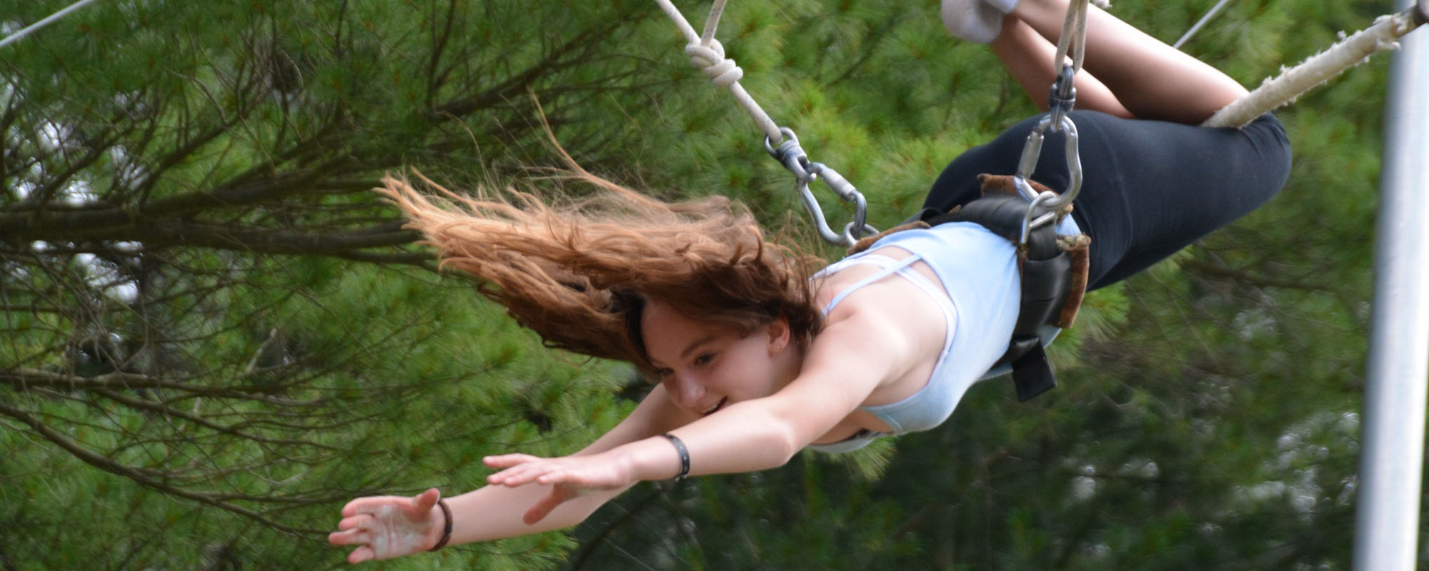 Camper reaching on trapeze